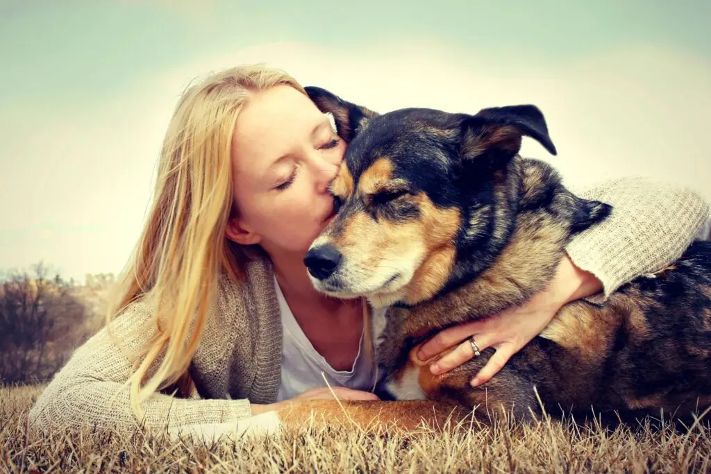 woman kissing dog