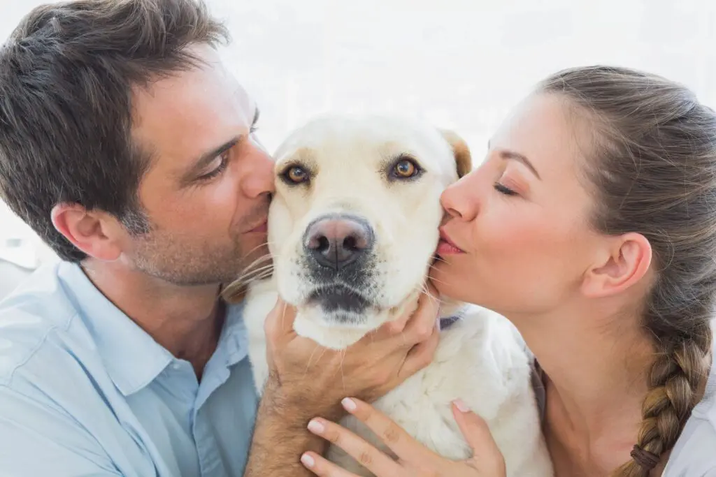 young couple kissing dog