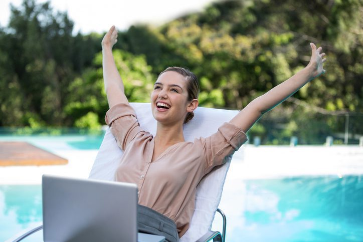 Woman by pool with lap top.