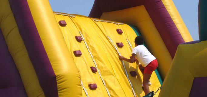 Child climbing up an inflatable climbing wall