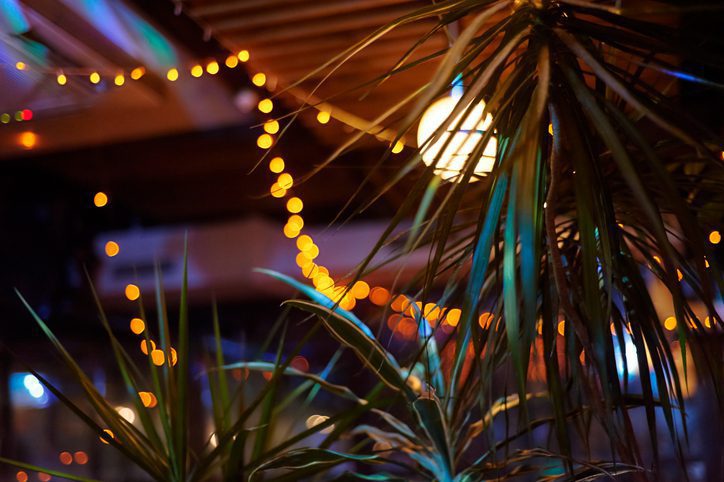 tropical bar athmocphere background with yellow garland bokeh. vacation night life concept.