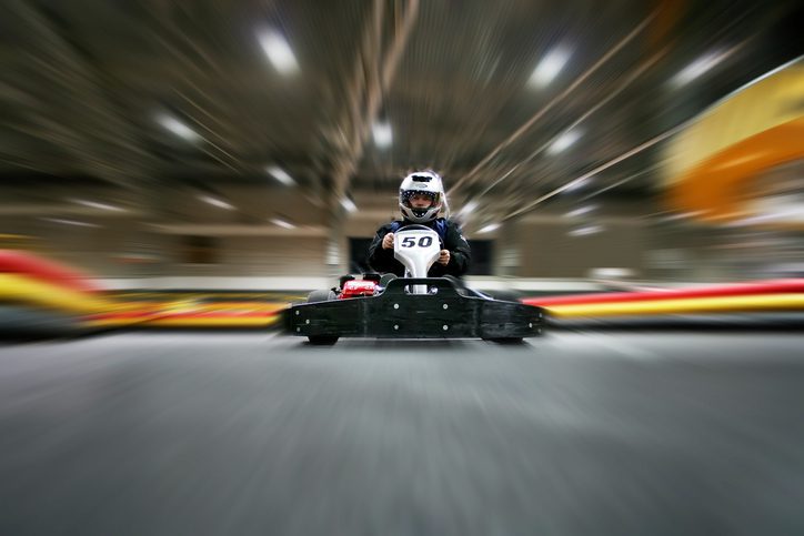 The man in a helmet in the go-kart moves on a karting track