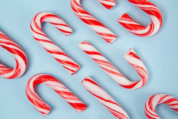 Christmas candy canes pattern on blue background - top view