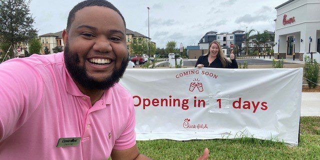 Leasing manager and property manager in front of Chick-fil-a opening day banner sign