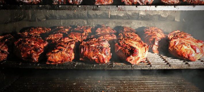 Pork being barbequed in a southern style pit over hickory wood.