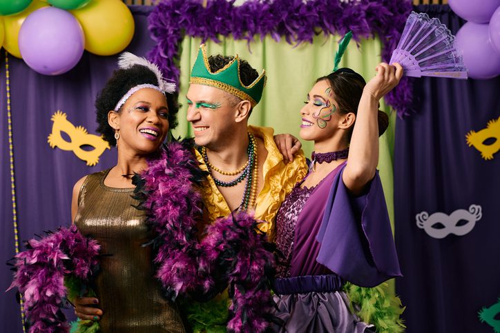 Three friends enjoy a Mardi Gras party in costumes