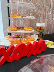 Red sign saying xoxo in front of a tray of donuts