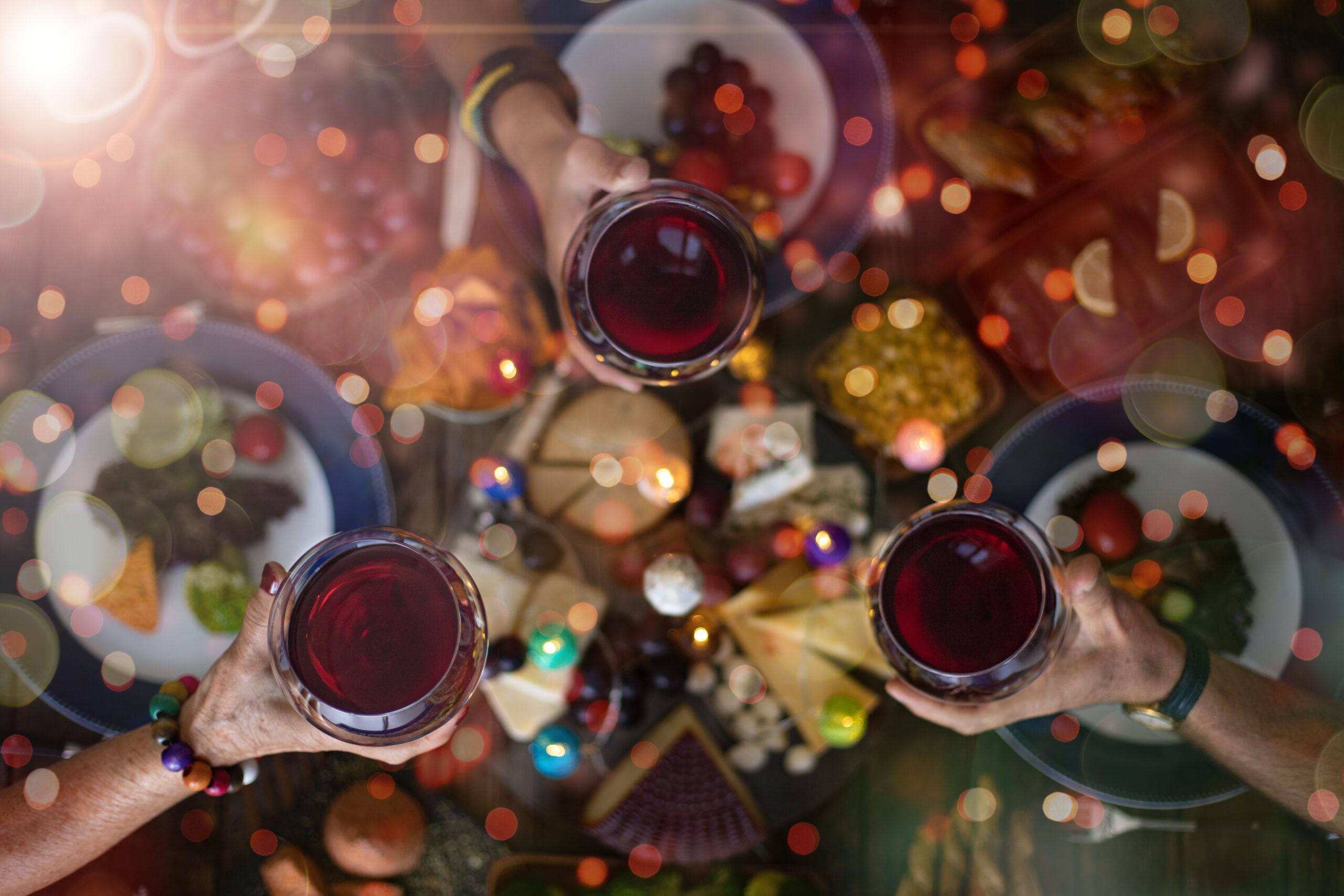Top view of a family gathering together with wine over food